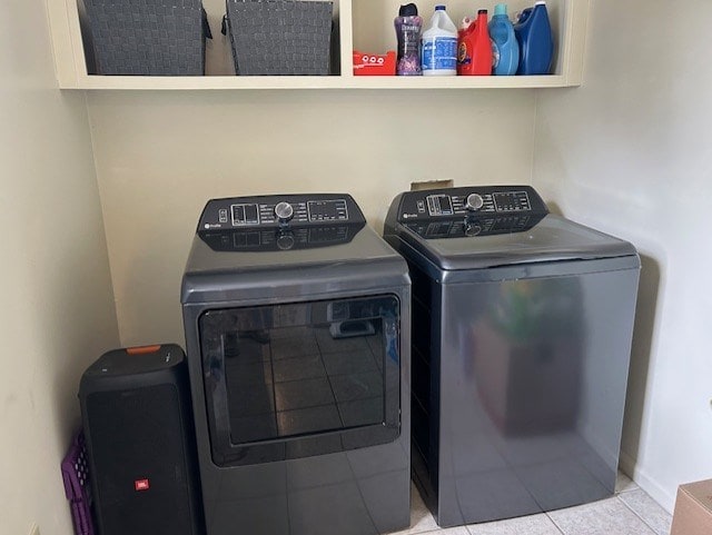 clothes washing area with separate washer and dryer, tile patterned floors, and laundry area