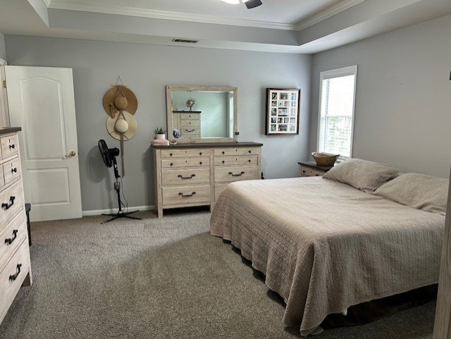 carpeted bedroom featuring baseboards, crown molding, a tray ceiling, and visible vents