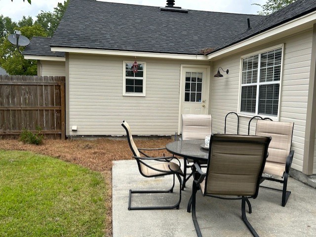 view of patio with outdoor dining space and fence