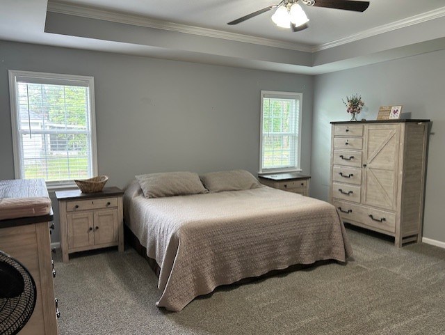 bedroom with a ceiling fan, baseboards, crown molding, and carpet