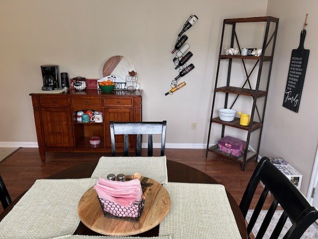 dining space featuring dark wood finished floors and baseboards
