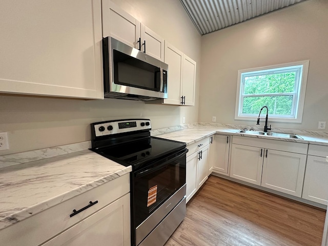 804 S Forrest Ave, Adel, GA 31620 - kitchen with stainless steel appliances, white cabinetry, light wood finished floors, and light stone countertops
