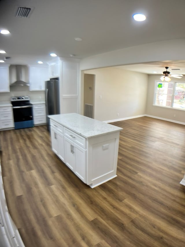 kitchen with stainless steel appliances, white cabinetry, dark hardwood / wood-style floors, and wall chimney range hood