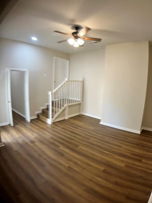 empty room with ceiling fan and dark wood-type flooring