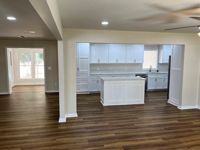 kitchen featuring dishwasher, a center island, sink, dark hardwood / wood-style floors, and white cabinets