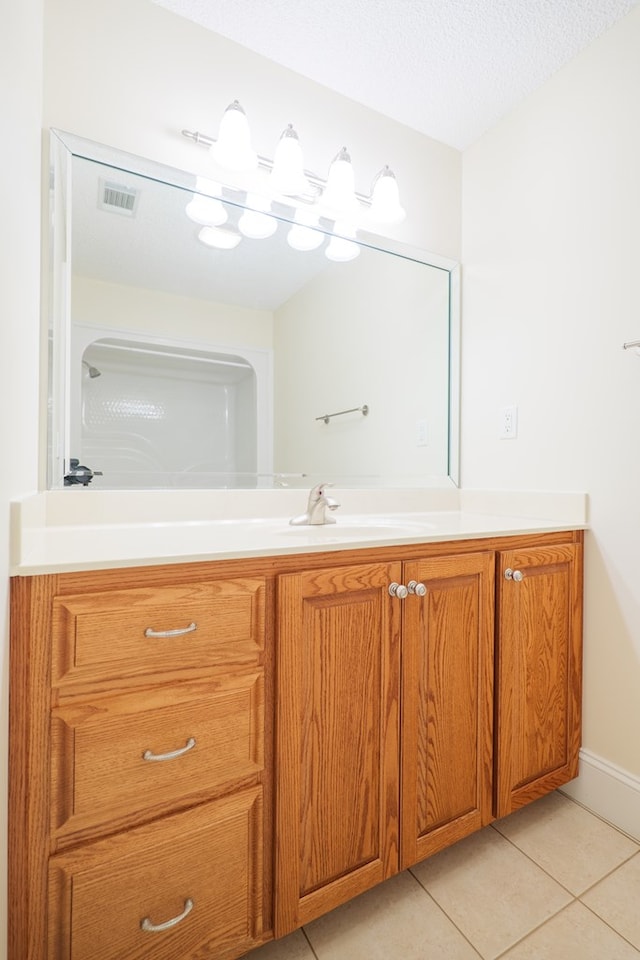 bathroom featuring vanity, visible vents, a textured ceiling, and tile patterned floors