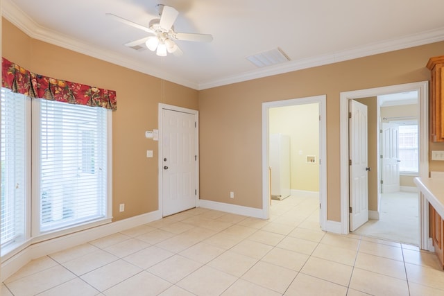 spare room with a wealth of natural light, visible vents, crown molding, and light tile patterned flooring