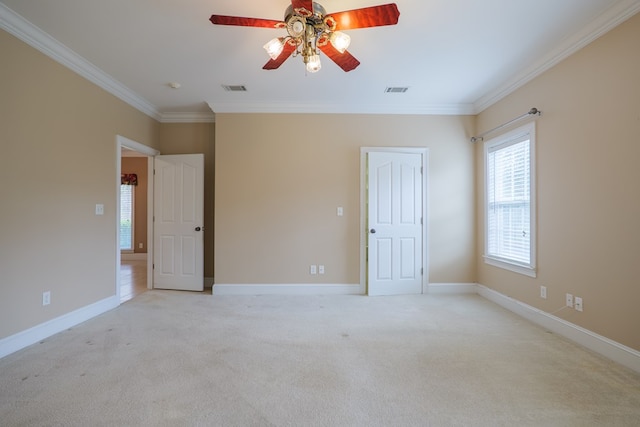 spare room with baseboards, visible vents, ornamental molding, and light colored carpet