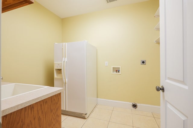 laundry area with laundry area, light tile patterned floors, hookup for a washing machine, electric dryer hookup, and a sink