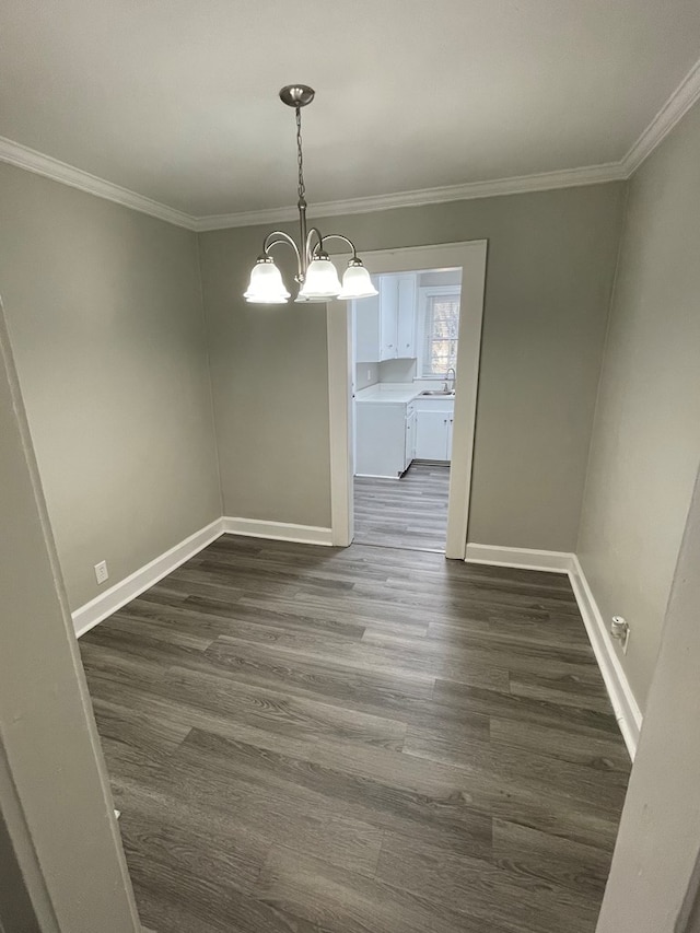 unfurnished dining area featuring a notable chandelier, dark hardwood / wood-style floors, sink, and crown molding