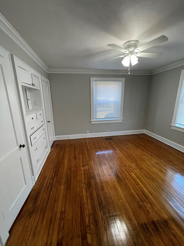 unfurnished bedroom with ceiling fan, dark hardwood / wood-style flooring, and crown molding