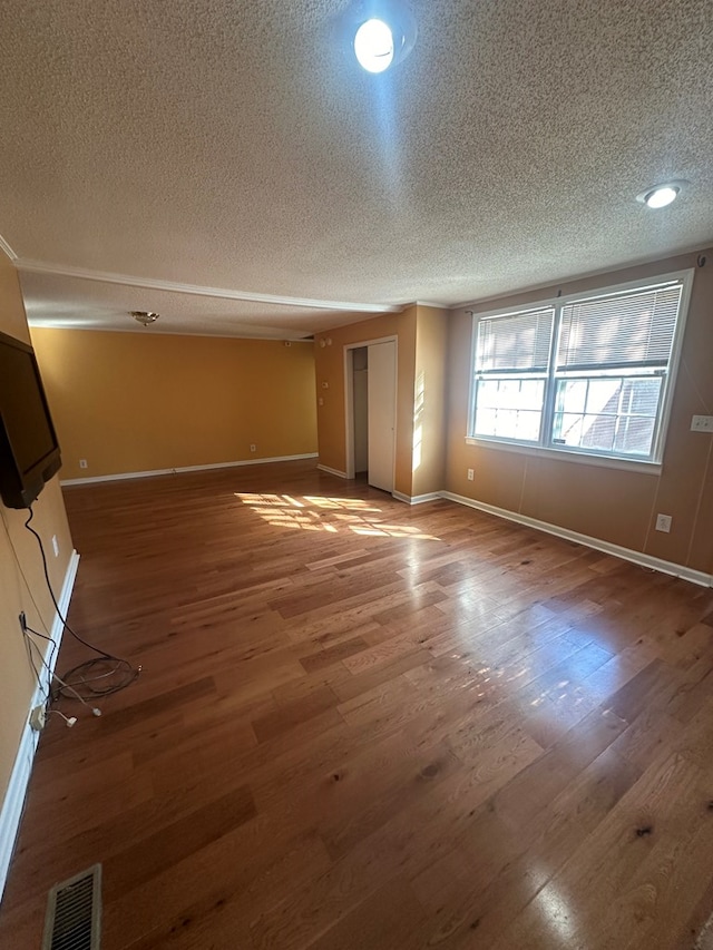 spare room with visible vents, baseboards, and wood finished floors