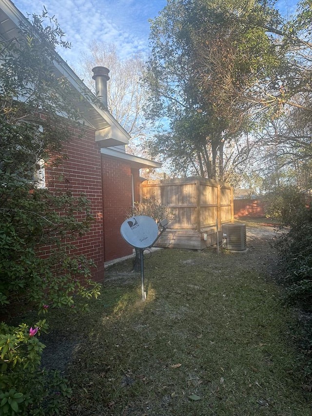 view of yard featuring fence and central AC