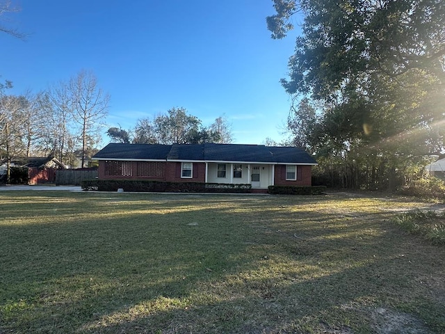 ranch-style house with a front yard and brick siding