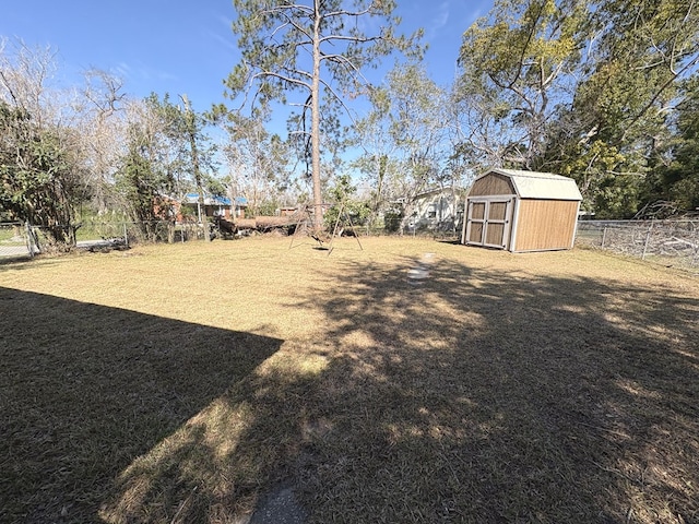 view of yard featuring a fenced backyard, an outdoor structure, and a storage shed