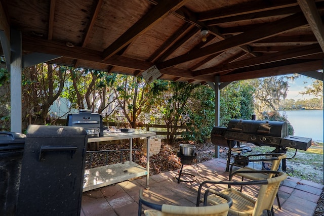 view of patio / terrace with a gazebo, an outdoor kitchen, a water view, and grilling area