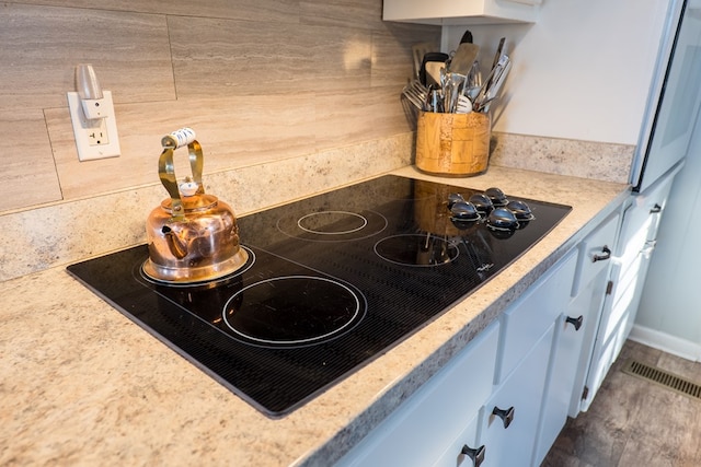 interior details featuring black electric cooktop and refrigerator