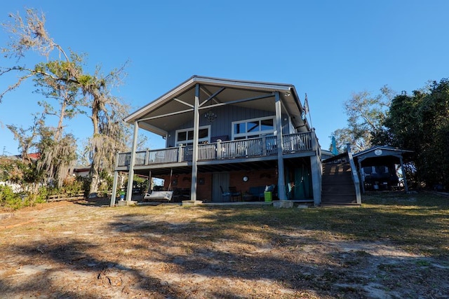 rear view of house featuring a lawn and a wooden deck