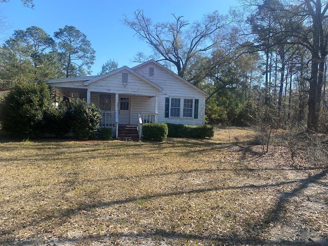 bungalow-style house featuring covered porch and a front yard