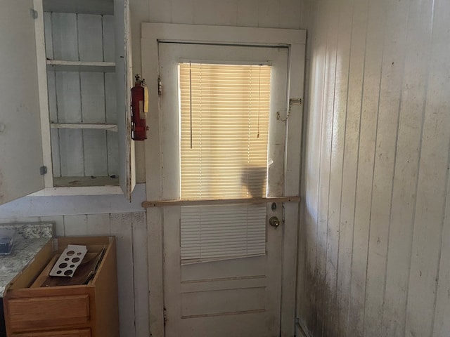 doorway featuring wood walls