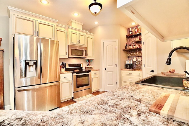 3342 Norton Pl, Valdosta, GA 31605 - kitchen featuring stainless steel appliances, open shelves, cream cabinets, recessed lighting, and light stone countertops