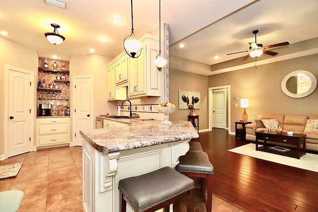 3342 Norton Pl, Valdosta, GA 31605 - kitchen with a peninsula, ceiling fan, open shelves, a kitchen bar, and open floor plan