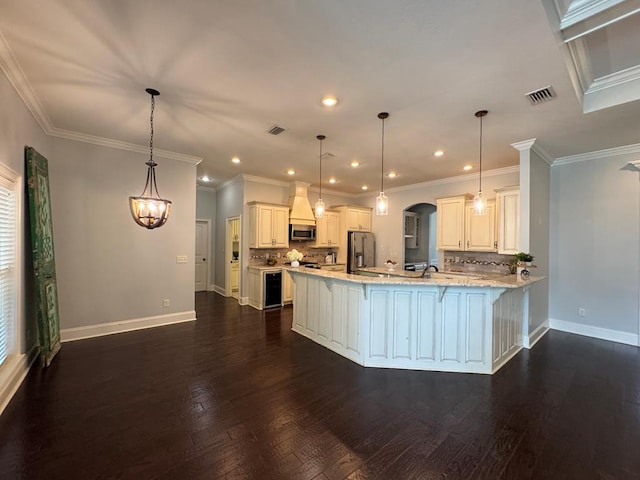 5029 Falling Spgs, Valdosta, GA 31602 - kitchen featuring appliances with stainless steel finishes, a peninsula, a kitchen bar, tasteful backsplash, and dark wood-style floors