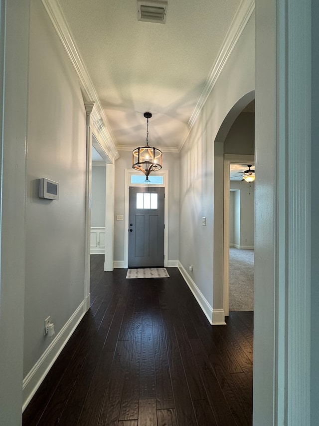 5029 Falling Spgs, Valdosta, GA 31602 - foyer entrance featuring arched walkways, dark wood finished floors, crown molding, a chandelier, and ceiling fan