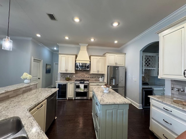 5029 Falling Spgs, Valdosta, GA 31602 - kitchen featuring premium appliances, beverage cooler, tasteful backsplash, crown molding, and light stone countertops