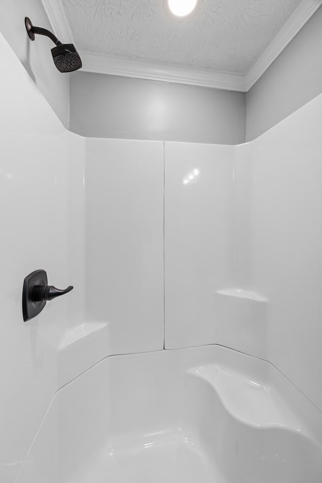 4848 Lori St, Valdosta, GA 31605 - bathroom view of a shower, ornamental molding, and a textured ceiling