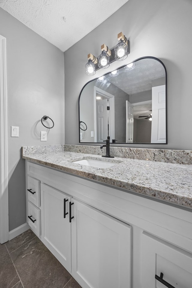 4848 Lori St, Valdosta, GA 31605 - bathroom with vanity, ceiling fan, a textured ceiling, and baseboards