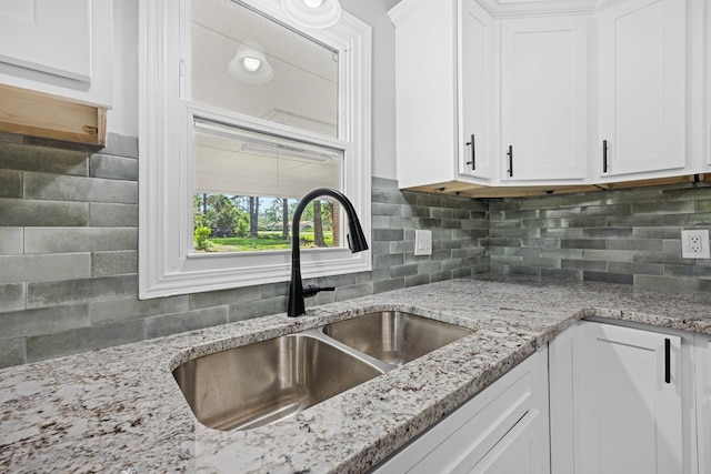 4848 Lori St, Valdosta, GA 31605 - kitchen with a sink, white cabinets, tasteful backsplash, and light stone countertops