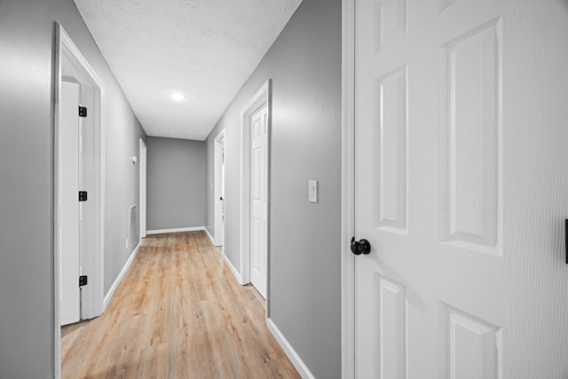 4848 Lori St, Valdosta, GA 31605 - hallway with light wood-style flooring, baseboards, and a textured ceiling