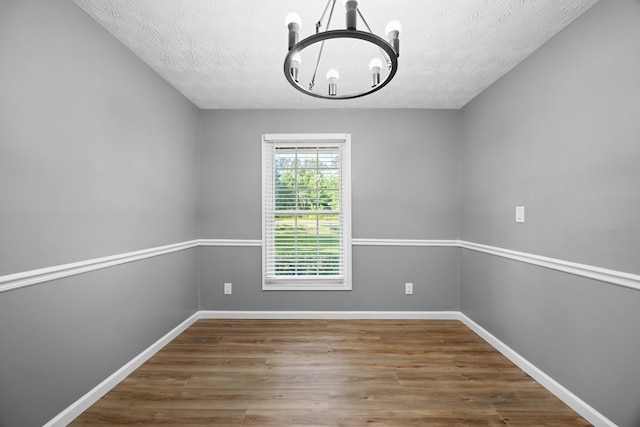 4848 Lori St, Valdosta, GA 31605 - spare room with a chandelier, wood finished floors, baseboards, and a textured ceiling