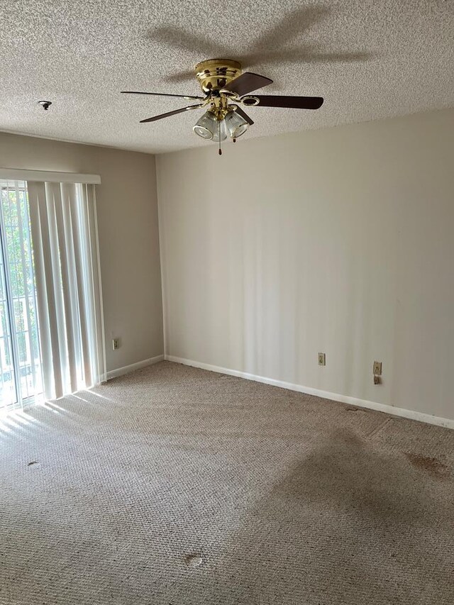 carpeted empty room with a textured ceiling and ceiling fan