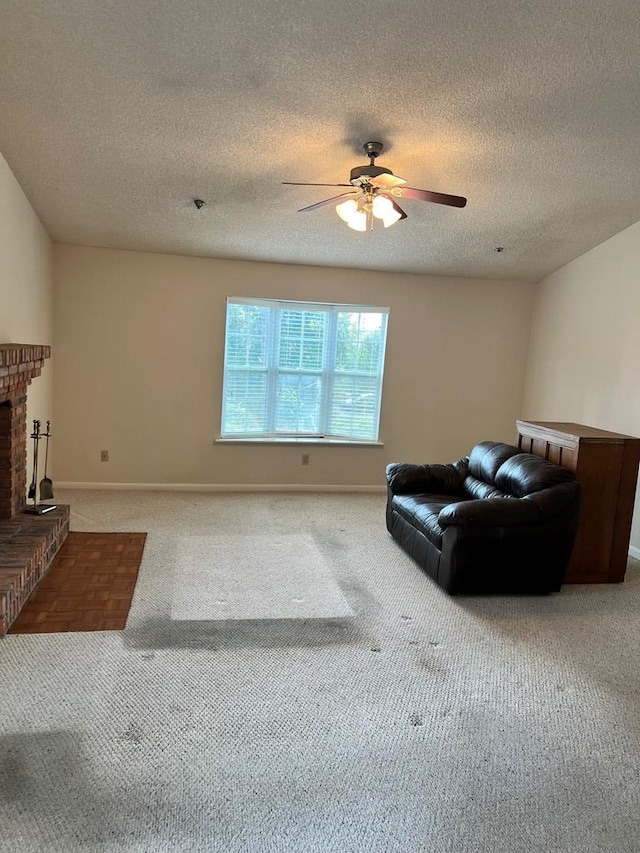 carpeted living room featuring ceiling fan, a fireplace, and a textured ceiling