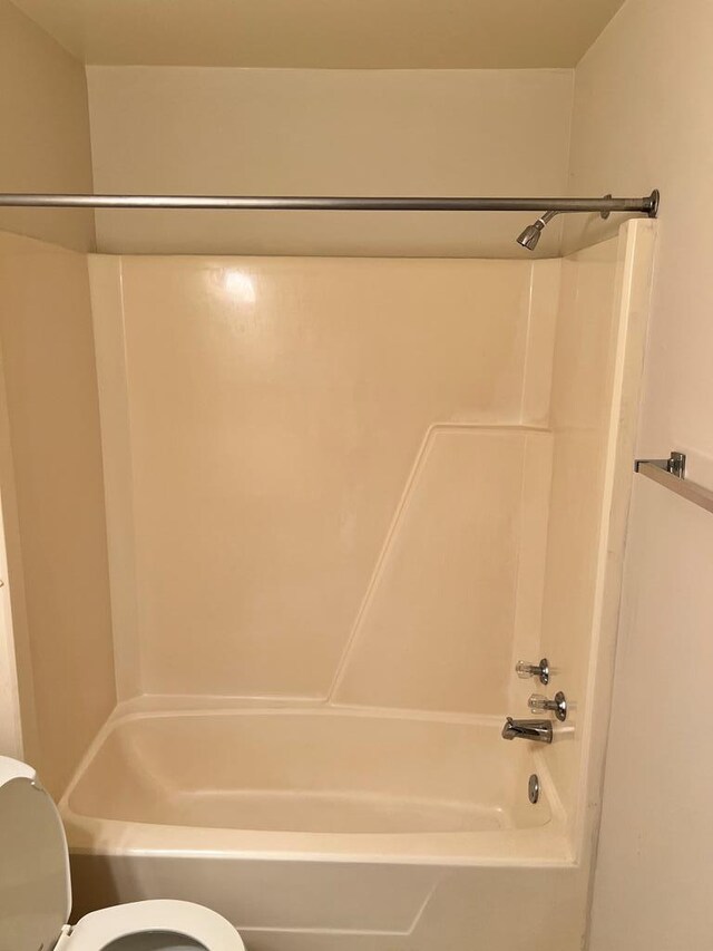 bathroom with shower / washtub combination and toilet