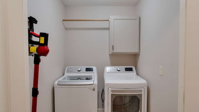 laundry area featuring washing machine and dryer and cabinets