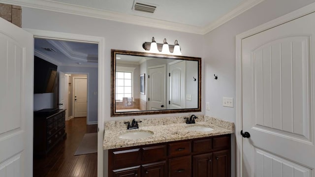 bathroom with crown molding, hardwood / wood-style floors, and vanity