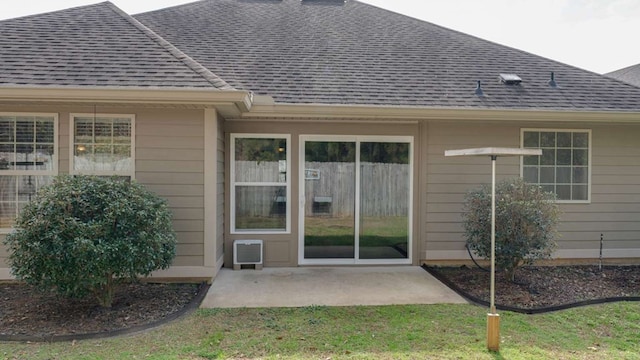 back of house featuring a lawn, a wall unit AC, and a patio area