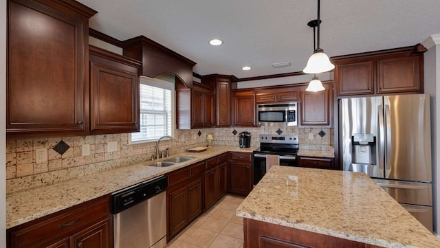 kitchen with pendant lighting, sink, light tile patterned floors, appliances with stainless steel finishes, and light stone counters