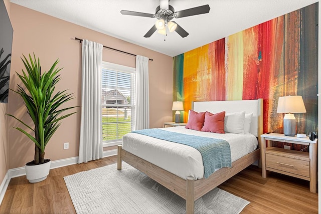 bedroom with baseboards, a ceiling fan, and wood finished floors