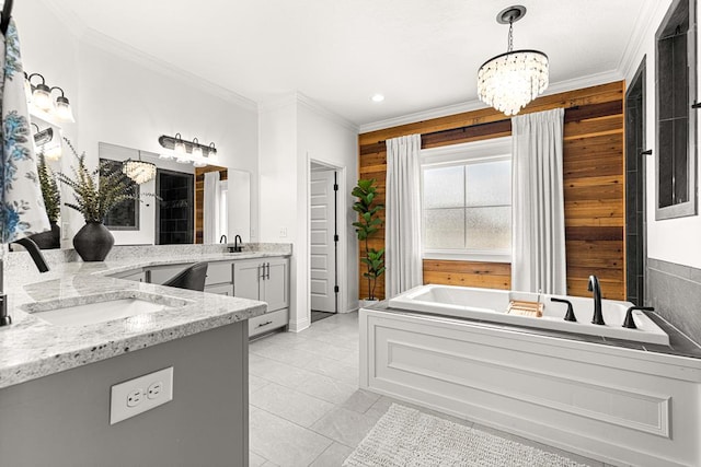 bathroom with a sink, two vanities, a notable chandelier, crown molding, and a bath