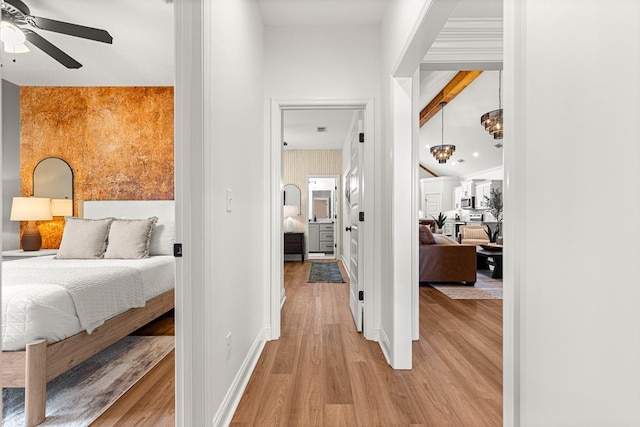 corridor featuring light wood finished floors and baseboards
