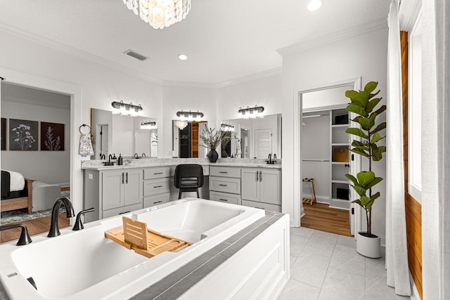 full bath with ornamental molding, vanity, visible vents, and a bathtub