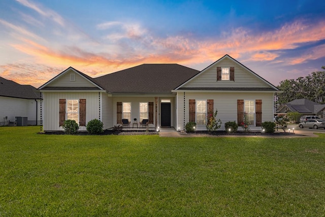 view of front of house featuring central air condition unit, a front lawn, and board and batten siding