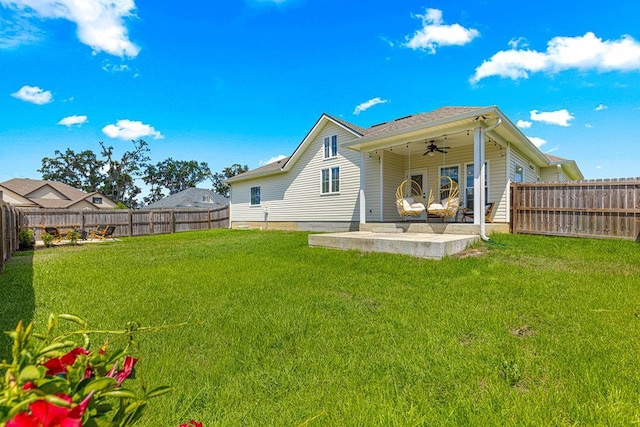 rear view of property with a yard, a patio area, a fenced backyard, and ceiling fan