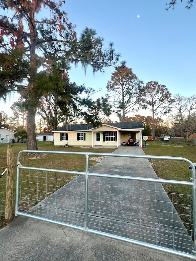 view of front of property with a gate and a lawn