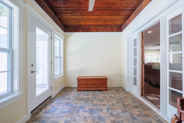 entryway featuring wooden ceiling and brick wall