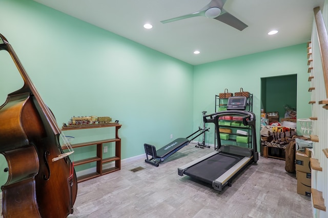 workout room with ceiling fan and light hardwood / wood-style flooring